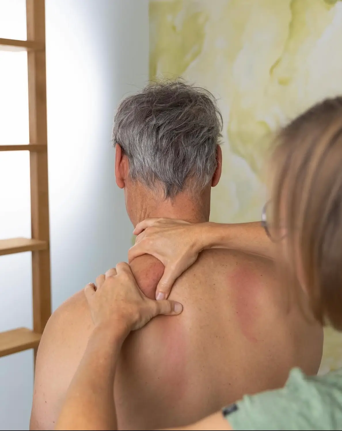 Close-up of a hands-on manual therapy session focusing on a patient's neck