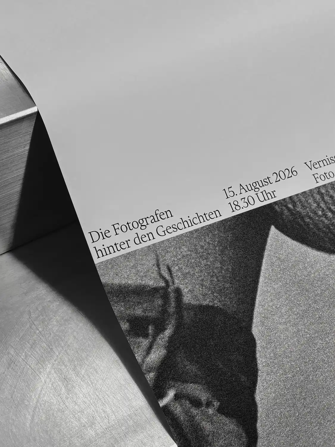 Close-up of a printed poster showing the elegant serif typography and grainy black-and-white photographic texture